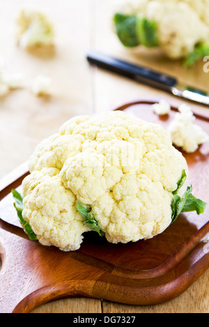 Frischer Blumenkohl mit Messer auf Schneidebrett Stockfoto