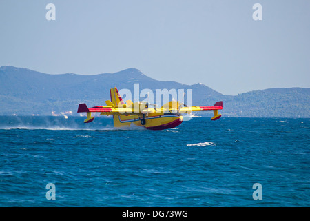Feuerwehr Flugzeug (Airtanker, Wasser Bomber) fliegen über dem Meer und unter Wasser Stockfoto