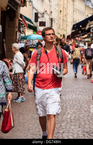 Männliche Touristen mit Körper Kamera ist Fuß durch die belebten Straße Mouffetard in Paris, Frankreich Stockfoto