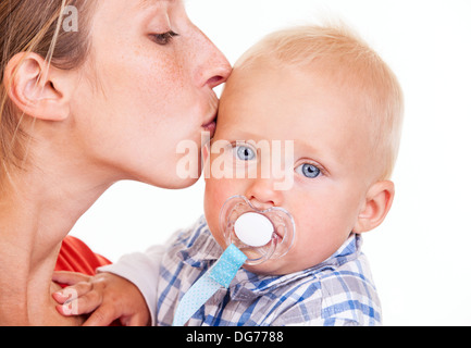 Kaukasische Mädchen küssen ihr Baby Sohn über weiß Stockfoto