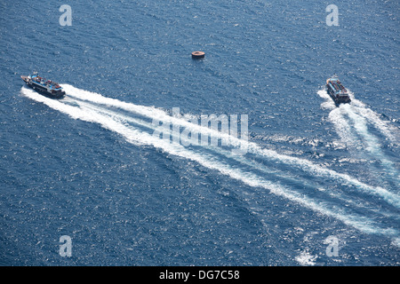 Zwei kleine Fähren im blauen Ägäischen Meer vor der Insel Santorini. Stockfoto