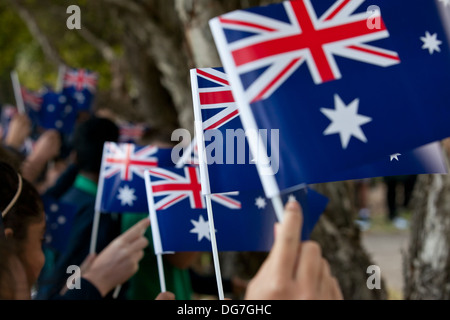 Kinder winken die australische Flagge bei ANZAC Tag Trauerfeier Stockfoto