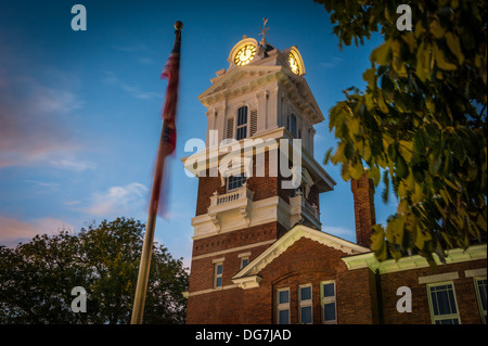 Im Glockenturm des Gwinnett Historic Courthouse in Lawrenceville, Georgia, nahe Atlanta leuchten die Uhren in den tiefen Abendtönen. (USA) Stockfoto