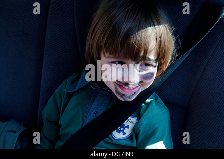 Vier Jahre alter Junge saß hinter dem Auto mit Sicherheitsgurt auf. Stockfoto