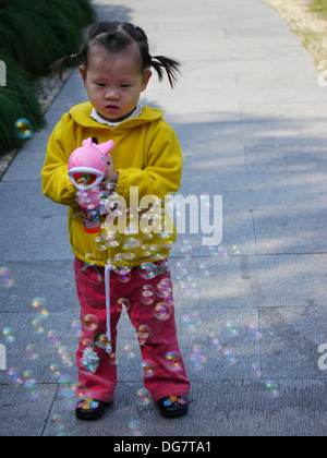 Chinesisches Kind spielt mit Seifenblasen Stockfoto