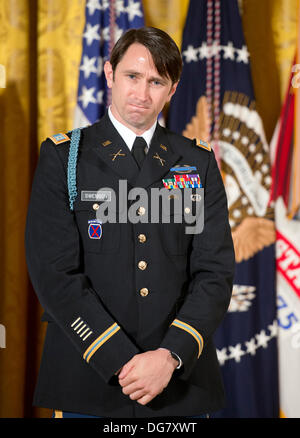 William Swenson, einem ehemaligen aktiven Dienst Armee Kapitän, der die Medal Of Honor für auffallende Tapferkeit verliehen wird, hört zu, als US-Präsident Barack Obama Bemerkungen im East Room des weißen Hauses in Washington, DC am 14. Oktober 2013 macht. Kapitän Swenson akzeptiert die Medal Of Honor für seinen mutigen Taten während seiner Tätigkeit als Embedded Trainer und Mentor der afghanischen nationalen Sicherheitskräfte mit afghanischen Grenze Mentor Polizeiteam, 1. Bataillon, 32. Infanterie-Regiment, 3rd Brigade Combat Team, 10th Mountain Division während der Kampfhandlungen in der Provinz Kunar, Afghanistan auf Stockfoto