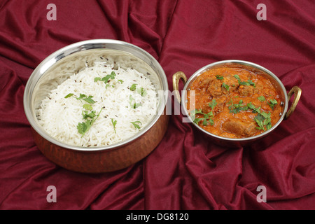 Lamm Rogan Josh, serviert mit Jeera (Kreuzkümmel) Reis in geschlagenem Kupfer Schalen (geschossen mit Tilt-Shift-Objektiv) Stockfoto