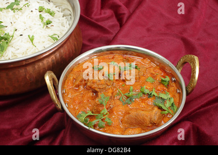 Lamm Rogan Josh, serviert mit Jeera (Kreuzkümmel) Reis in geschlagenem Kupfer Schalen (geschossen mit Tilt-Shift-Objektiv) Stockfoto