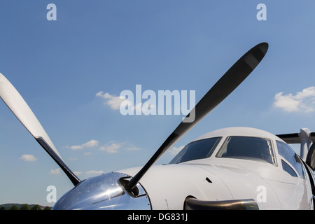 Nase und Spinner von einem privaten Flugzeug - Pilatus PC-12 vor einem blauen Himmel mit ein paar Wolken Stockfoto