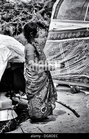 Niedrigere Kaste indische schwangere Teenager-Mädchen warten auf freie Nahrung und Kleidung vor ihrem Zelt Haus erhalten. Andhra Pradesh, Indien Stockfoto