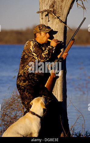 Eine Ente Jäger aufrufenden Enten mit seinem gelben Labrador Retriever Jagdhund in einem Sumpf-See in der Nähe von Austin Texas Stockfoto