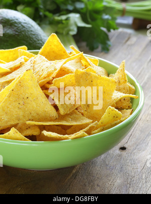 Mais-Chips (Nachos) in einer grünen Schale auf Holztisch Stockfoto