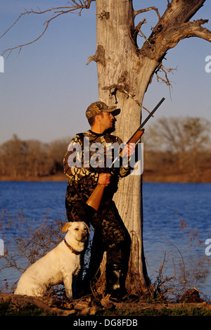 Eine Ente Jäger aufrufenden Enten mit seinem gelben Labrador Retriever Jagdhund in einem Sumpf-See in der Nähe von Austin Texas Stockfoto