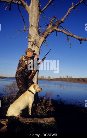 Eine Ente Jäger aufrufenden Enten mit seinem gelben Labrador Retriever Jagdhund in einem Sumpf-See in der Nähe von Austin Texas Stockfoto