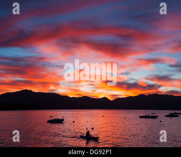 Dramatischen Sonnenuntergang über Lake Tahoe mit Berge Silhouette, Kajakfahrer und Boote Stockfoto