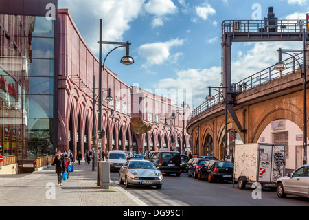 Straße, gesäumt mit rosa Arkaden Gebäude der Alexa Shopping Center und Geschäfte unter der Bahn verfolgt, Alexander Platz, Berlin Stockfoto