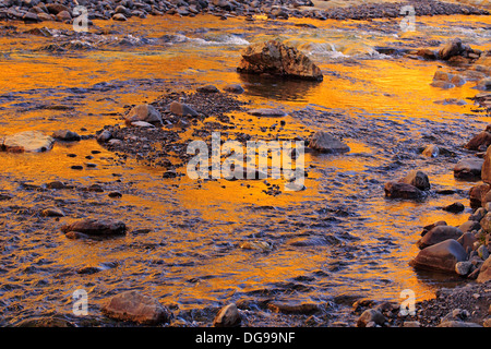 Sonnenuntergang abprallen gelblich Rock spiegelt sich in der Höhle Stream Stockfoto