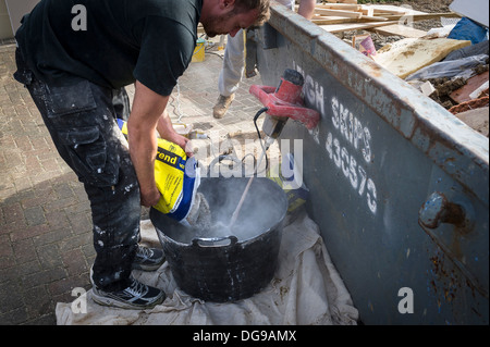 Ein Arbeiter mischen von Beton Rendern in einer Wanne. Stockfoto