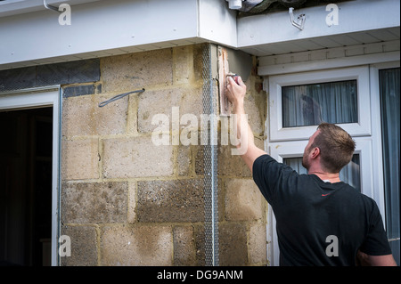 Ein Arbeiter Rendern einer Außenwand eines Hauses. Stockfoto