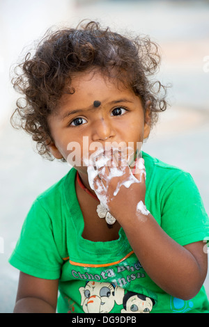 Junge Inderin / Kleinkind Essen ein Eis in einem indischen Dorf. Andhra Pradesh, Indien Stockfoto