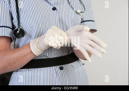 Krankenschwester ziehen am OP Gummihandschuhe Stockfoto