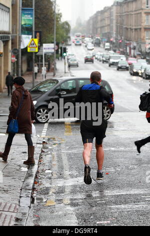 Kelvinbridge, Glasgow, Schottland, Großbritannien. 17. Oktober 2013. Dauerregen und ein echtes Gefühl des Herbstes stoppen nicht die Leben vieler, da jeder über ihr tägliches Geschäft geht. Paul Stewart/Alamy News Stockfoto