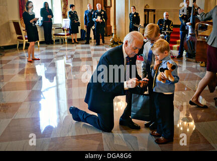 US-Vizepräsident Joe Biden Hände Kinder ausgestopfte Tiere während der Medal Of Honor-Zeremonie im Weißen Haus 15. Oktober 2013 in Washington, DC. Die Medal Of Honor ist die höchste militärische Auszeichnung des Landes. Stockfoto