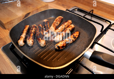 Würstchen aus Schweinefleisch kochen in einer Pfanne schwenken suchen verbrannt und verkohlt Stockfoto