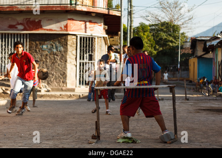 Eine Gruppe kleiner Jungs, die auf der Straße Fußball spielen Stockfoto