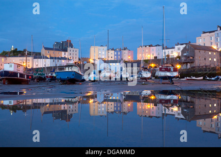 Tenby Hafen in der Abenddämmerung mit Reflexion der Boote und Häuser in Lache des Wassers bei Ebbe Tenby Pembrokeshire West Wales UK Stockfoto