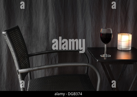 Gemütliche Laterne Dekoration einen Tisch mit Glas Rotwein. Stockfoto