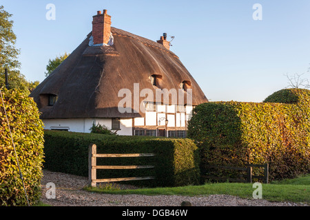 Traditionellen Reetdachhaus auf Landstraße in englischen Landschaft Dorf. Stockfoto