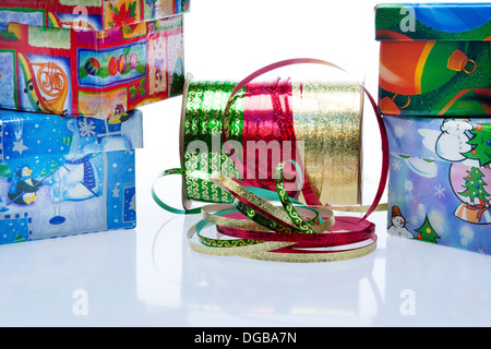 Weihnachtsgeschenke mit rot, grün und gold Band auf Spule in Mitte Stockfoto