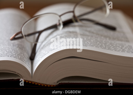 Paar Gläser Verlegung auf ein offenes Buch. Stockfoto