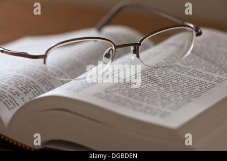 Paar Gläser Verlegung auf ein offenes Buch. Stockfoto