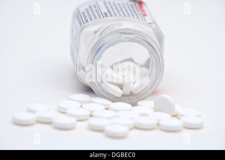 Aspirin-Tabletten eine Pille Flasche ausgießen, auf weißem Hintergrund Stockfoto