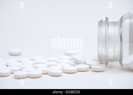 Aspirin-Tabletten eine Pille Flasche ausgießen, auf weißem Hintergrund Stockfoto