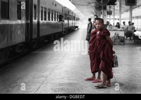 Zwei nicht identifizierte junge Novizen warten auf den Zug am Hauptbahnhof in Yangon, Myanmar Stockfoto