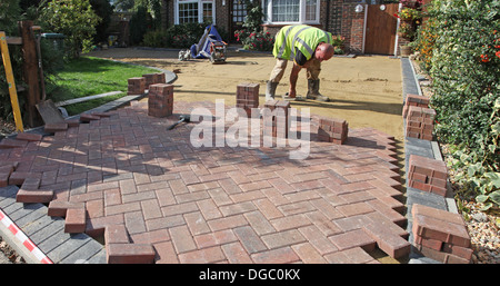 Projektphase 4 einen Block legen gepflastert Laufwerk. Die Blöcke liegen auf Sand. Stockfoto