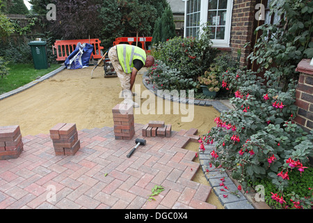 5. Etappe eines Projekts einen Block legen gepflastert Laufwerk. Die Blöcke liegen auf Sand. Stockfoto