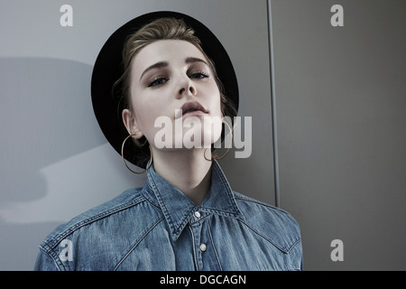 Junge Frau mit Hut und Hoop Ohrringe, portrait Stockfoto