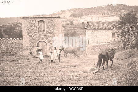 Bauern Dreschen Weizen Tiere. Jahrgang 1930. Landhaus. Zwei Mädchen Blick auf die Arbeit der Landwirte. Stockfoto
