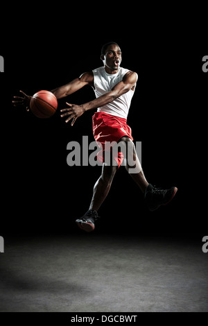Junge männliche Basketball-Spieler wirft ball Stockfoto