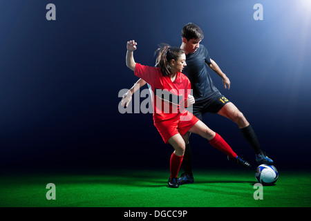 Männliche und weibliche Fußball-Spieler in Aktion Stockfoto