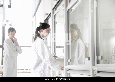 Chemiestudenten durch Rauch Schrank im Labor Stockfoto