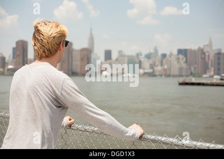 Junger Mann, Blick auf Skyline, Brooklyn, New York City, Vereinigte Staaten Stockfoto