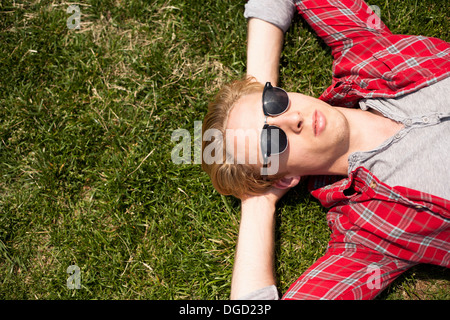Junger Mann liegend im park