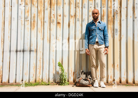 Porträt des jungen Mannes vor Wellpappe Zaun Stockfoto