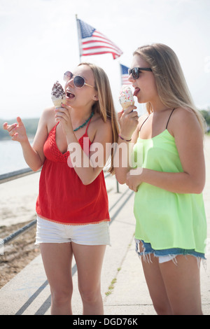 Junge Frauen, die Eis essen am Strand Stockfoto