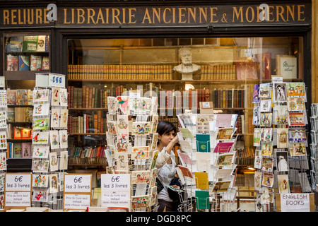 Junge Frau einkaufen bei einem antiken Buchladen in Passage Vivienne, Paris Frankreich Stockfoto